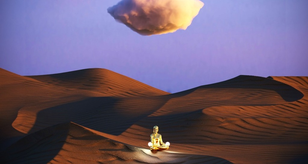 Estatua de una persona meditando en el desierto con una nube sobre su cabeza