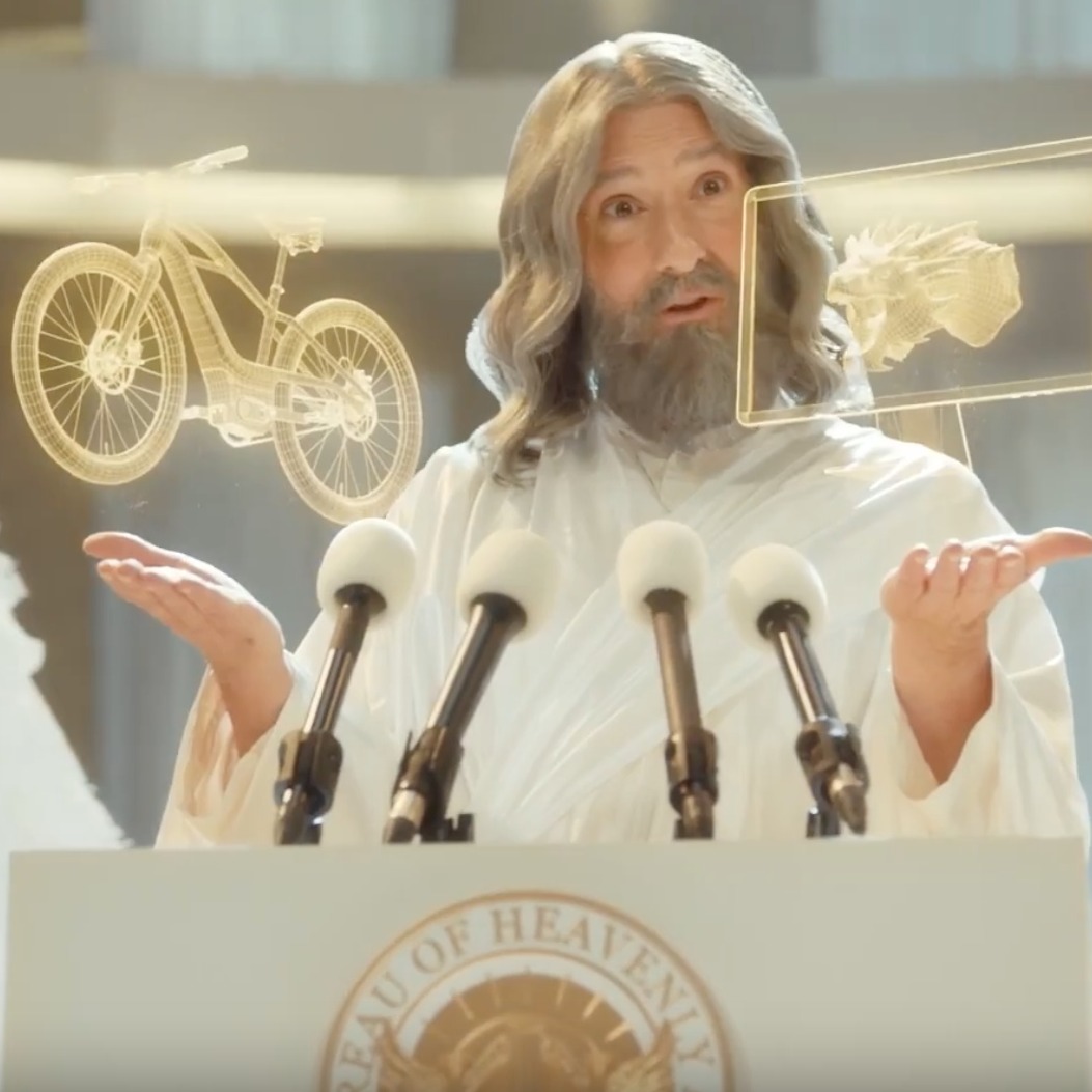 Dios destaca el poder creador de los humanos en este anuncio de Autodesk dios en un atril dando una rueda de prensa con cara de sorpresa