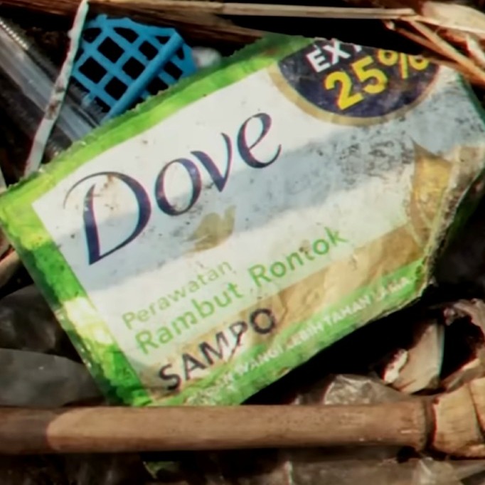 un paquete de champú de dove en la basura contaminando