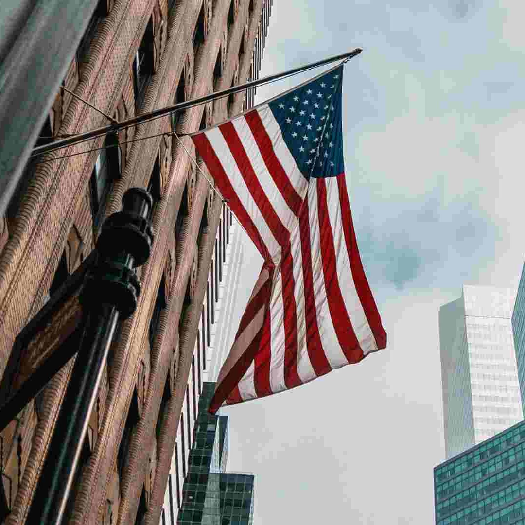 Bandera de Estados Unidos ondea entre edificios de oficinas