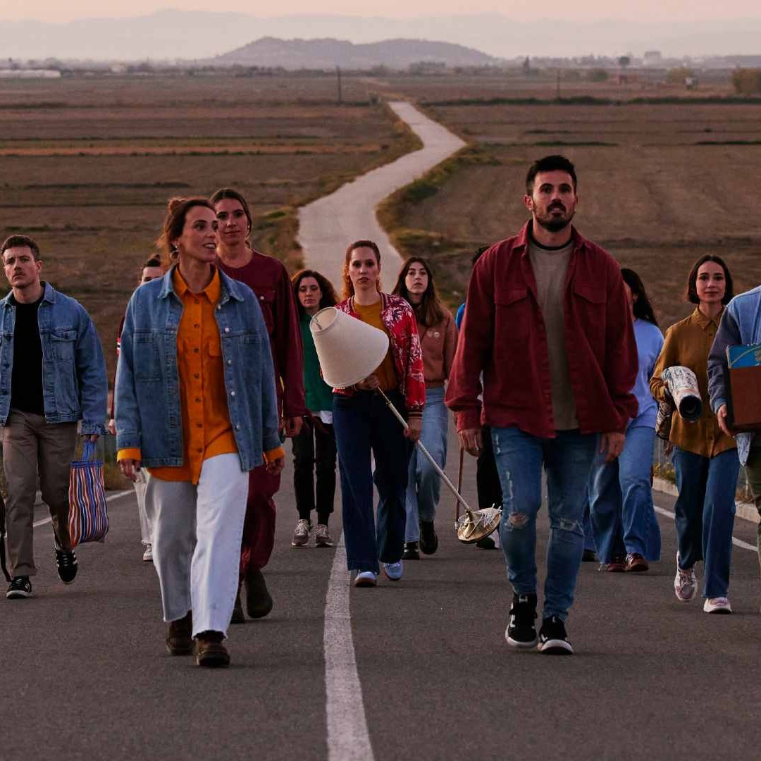 Grupo de personas caminando por una carretera