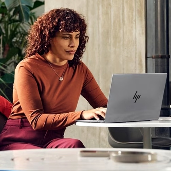 HP entra en el negocio publicitario con su propia red de anuncios y una plataforma de streaming integrada en sus portátiles una mujer trabajando en una cafeteria con su ordenador portatil