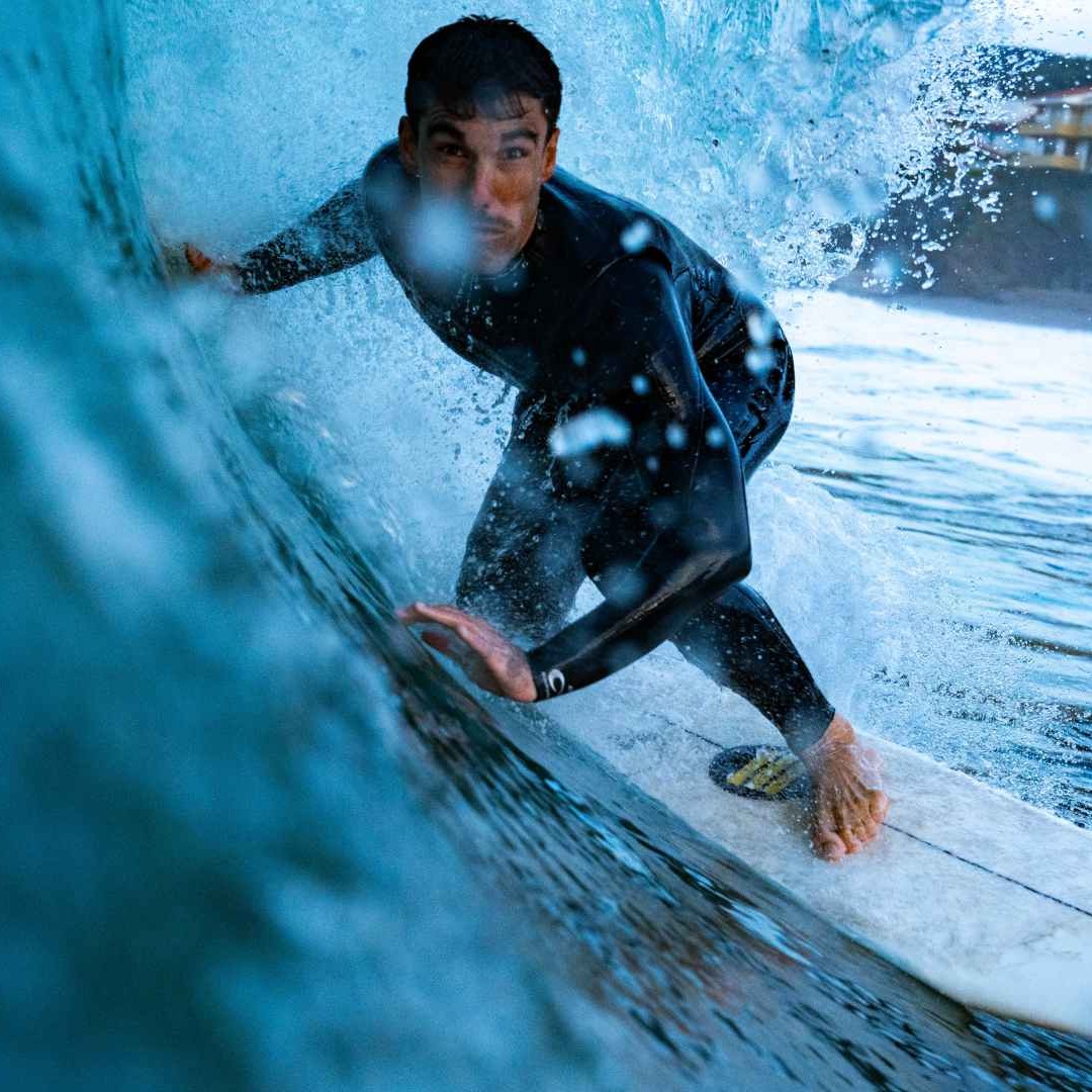 Hombre haciendo surf y surcando una ola