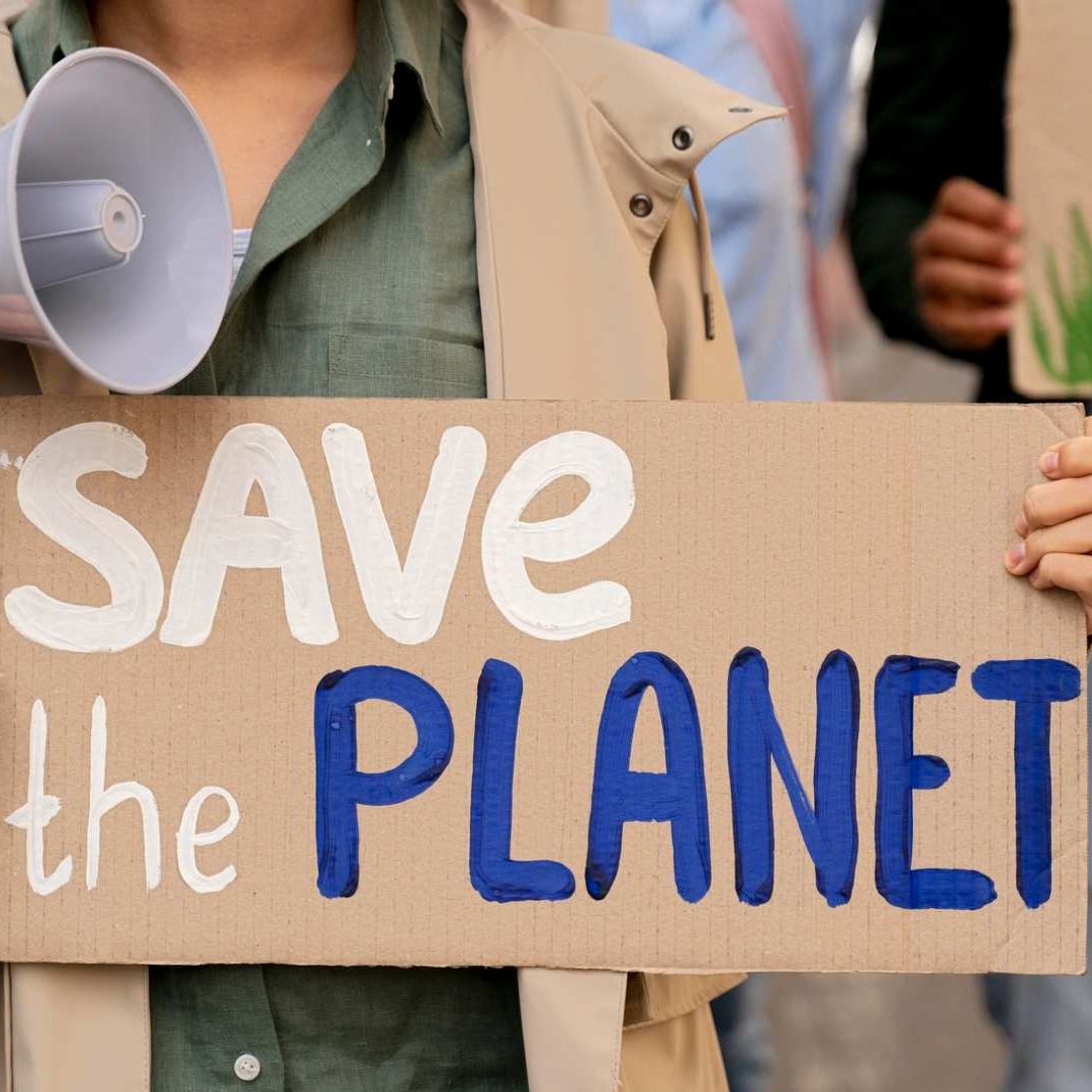 Mujer sostiene una pancarta con el mensaje "Save the planet"