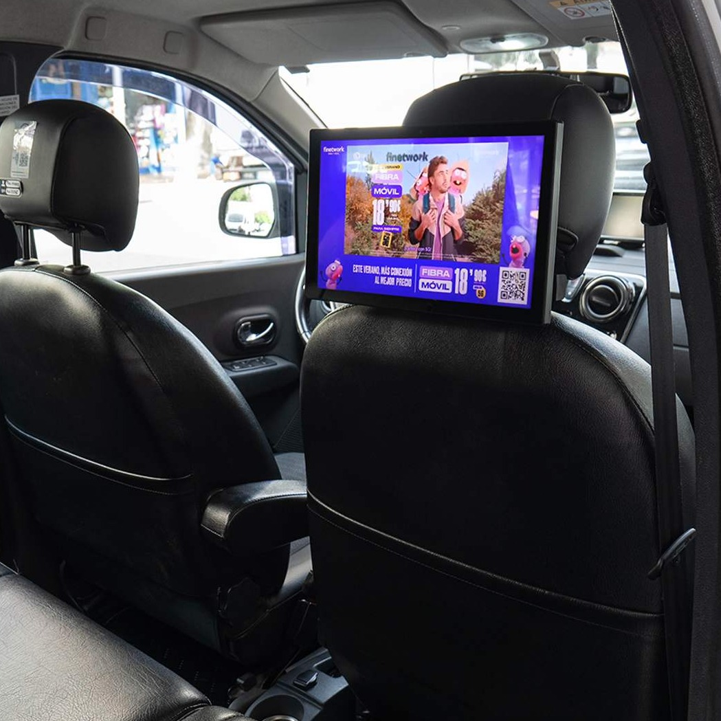 una pantalla en el interior de un taxi, sujeta en el asiento del copiloto