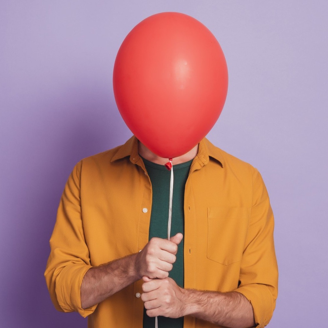 Chica oculta su cara tras un globo