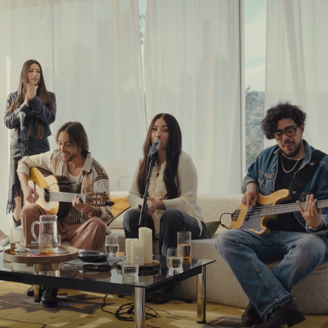 Grupo de músicos interpretando una canción en un salón.