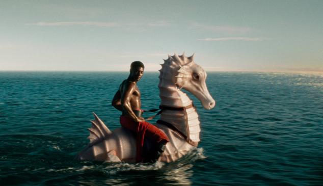 Hombre montado en un caballito de mar gigante navegando