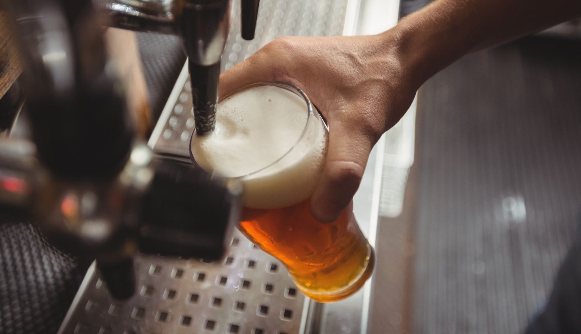 Hombre llenando un vaso de cerveza de grifo