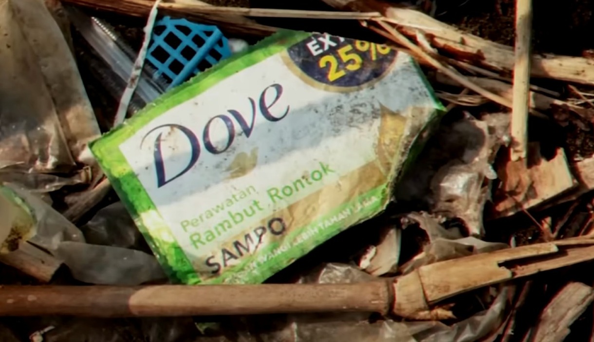 un paquete de champú de dove en la basura contaminando