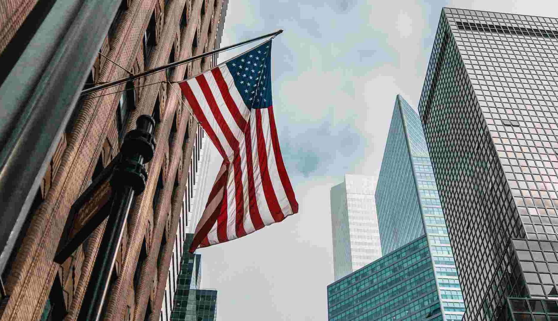 Bandera de Estados Unidos ondea entre edificios de oficinas