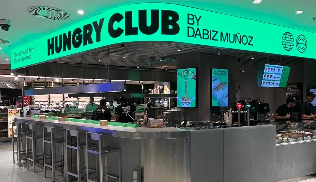 barra del restaurante hungry club by dabiz muñoz con sillas altas y pantallas que muestran los productos