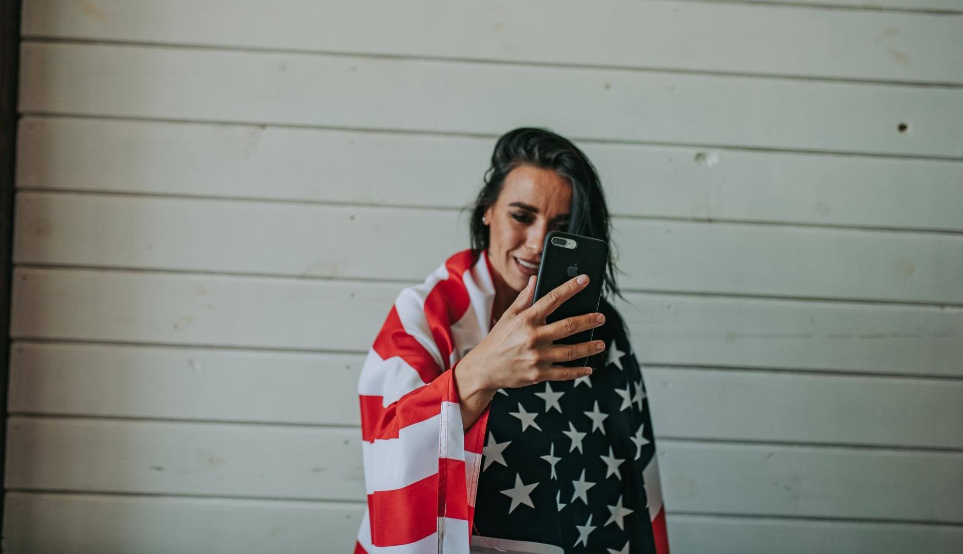 Chica con la bandera estadounidense se graba con el móvil