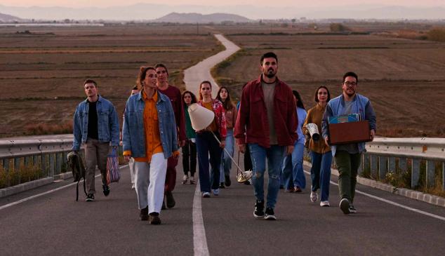 Grupo de personas caminando por una carretera