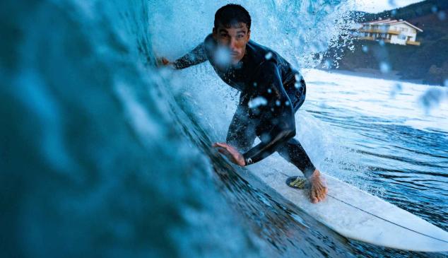 Hombre haciendo surf y surcando una ola