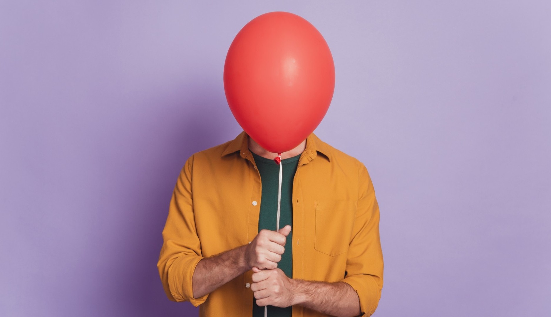 Chica oculta su cara tras un globo