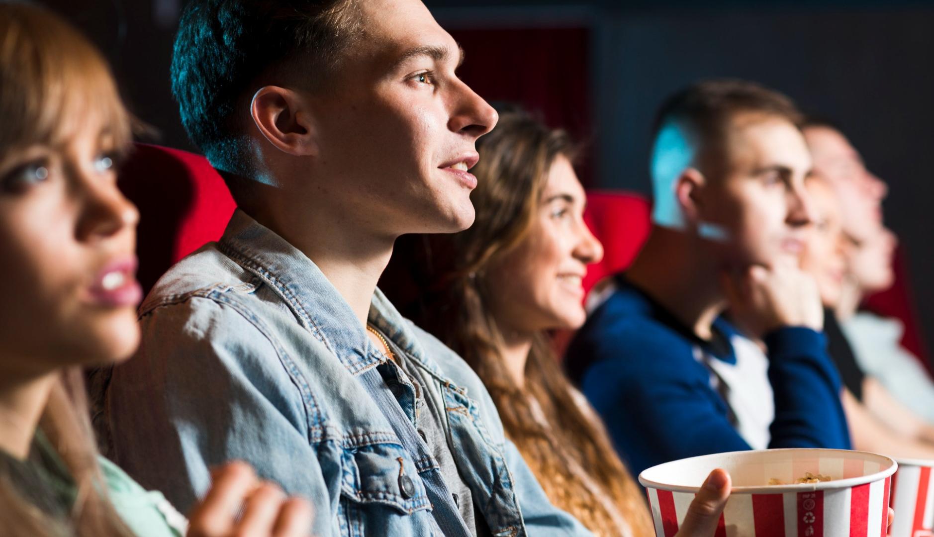 Gente joven viendo una película en el cine