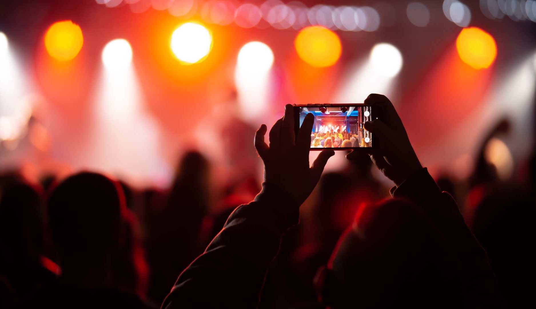 Persona graba un concierto con el móvil