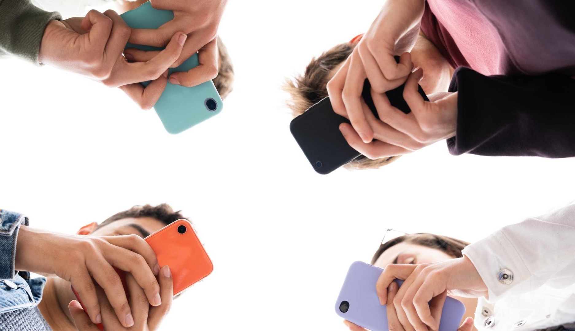 Adolescentes miran sus teléfonos móviles