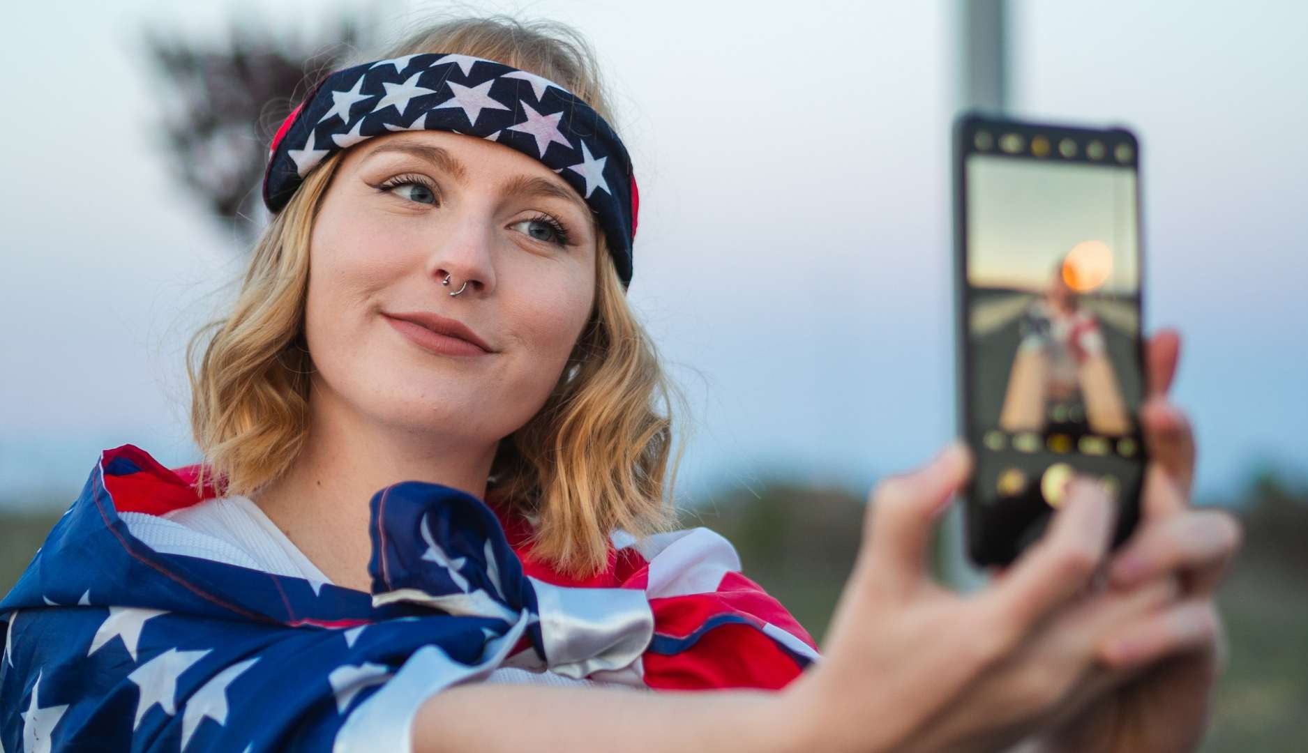 Chica con la bandera de Estados Unidos se graba en un vídeo para TikTok