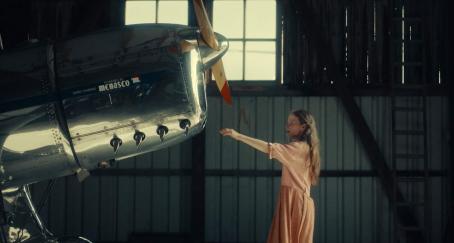 Un niña tocando un avión antiguo