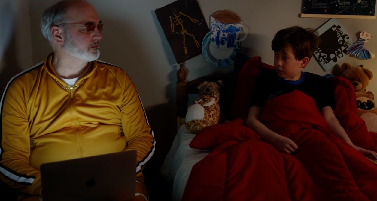 Niños y smartphones: esta campaña le da la vuelta al discurso denunciando la presión a la que se ven sometidos Un niño en su cama mirando a un señor que tiene al lado con un ordenador