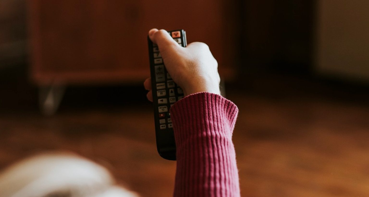 Mano sujetando un mando a distancia