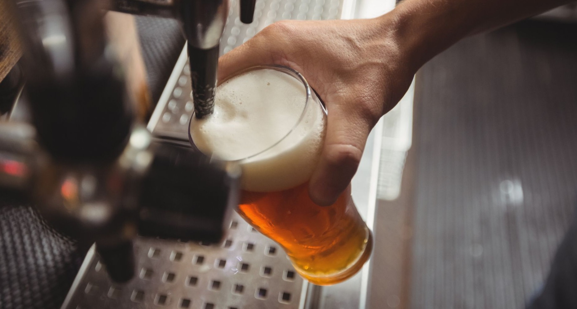 Hombre llenando un vaso de cerveza de grifo