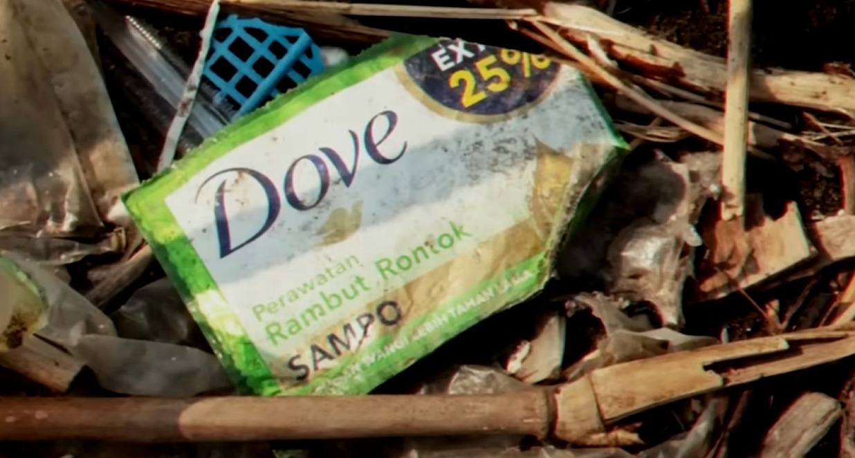 un paquete de champú de dove en la basura contaminando