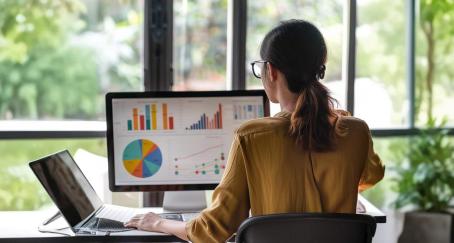 Mujer mirando gráficos en la pantalla de un ordenador