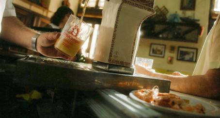 Sevilla tendrá un barrio dedicado a la cerveza para rendir homenaje a su relación con Cruzcampo y el sector una camarero tirando una cerveza de grifo en un bar junto a un plato de gambas