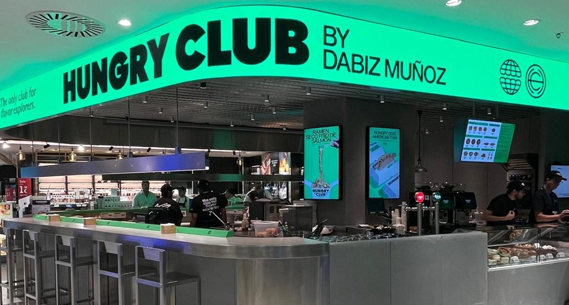 barra del restaurante hungry club by dabiz muñoz con sillas altas y pantallas que muestran los productos