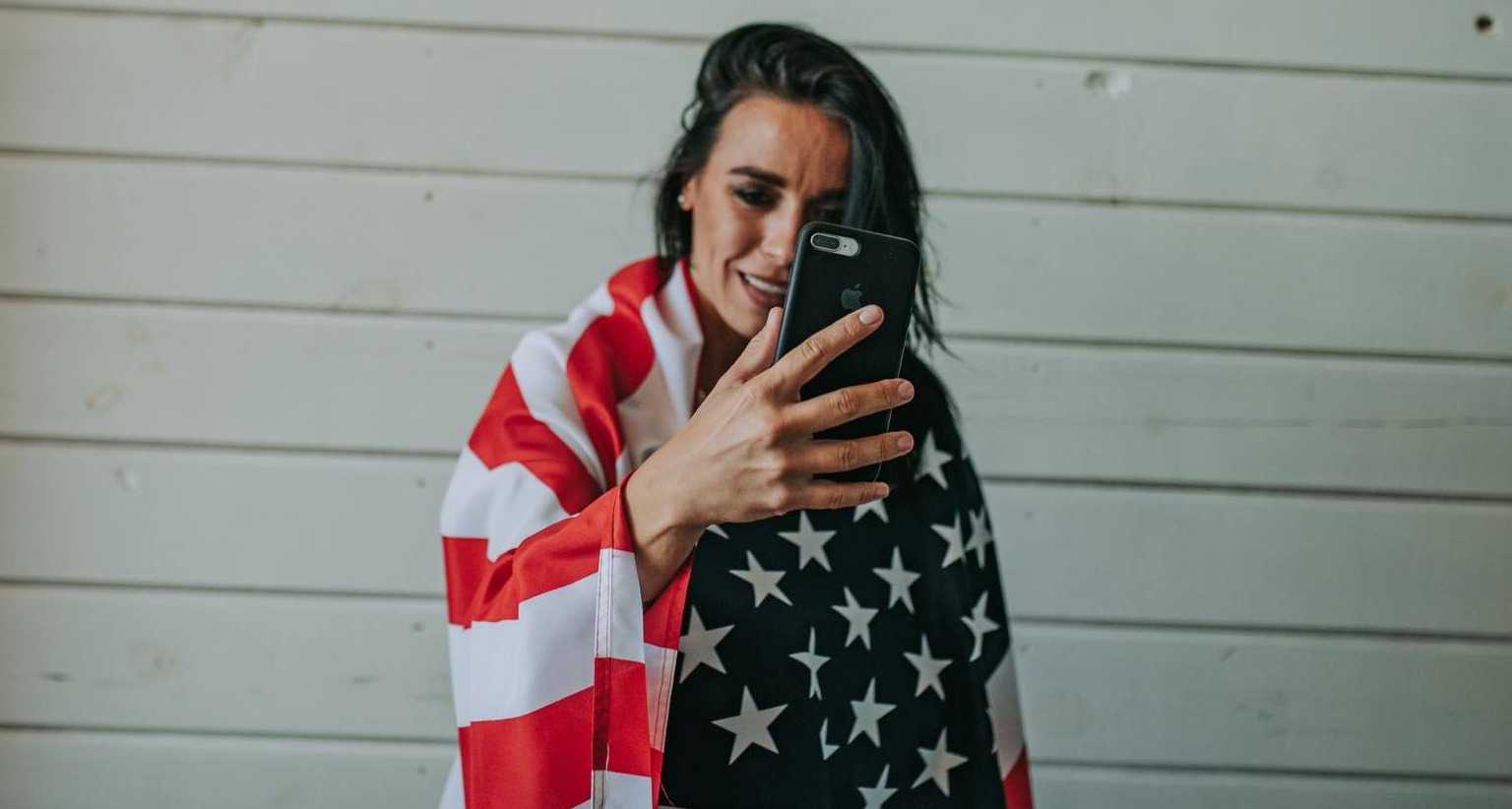 Chica con la bandera estadounidense se graba con el móvil