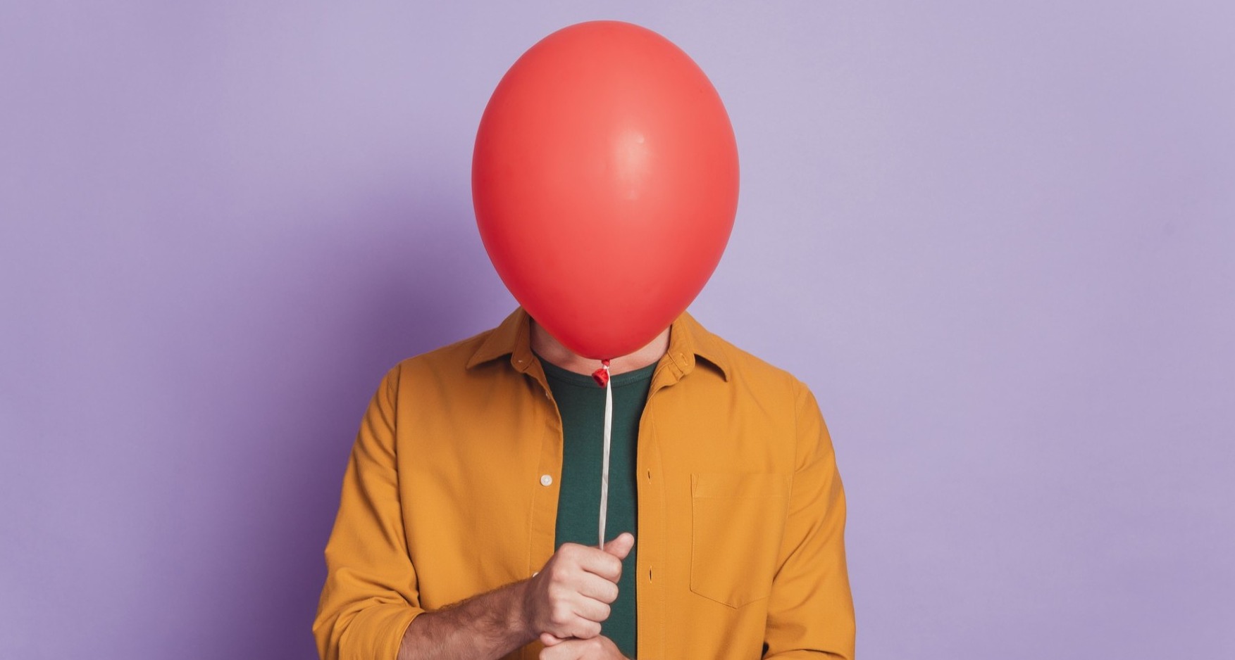 Chica oculta su cara tras un globo