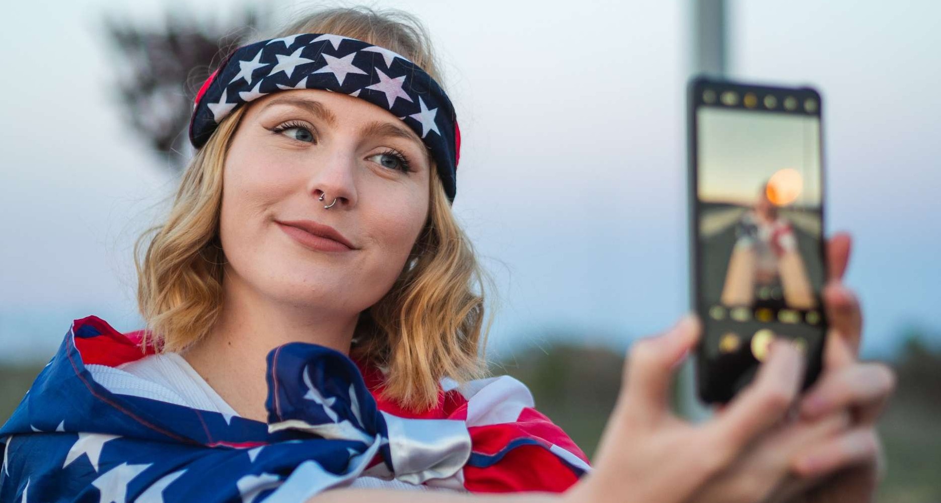 Chica con la bandera de Estados Unidos se graba en un vídeo para TikTok